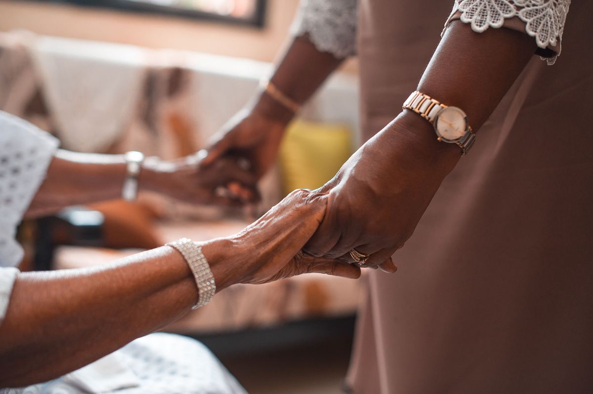 Support worker and participant holding hands warmly